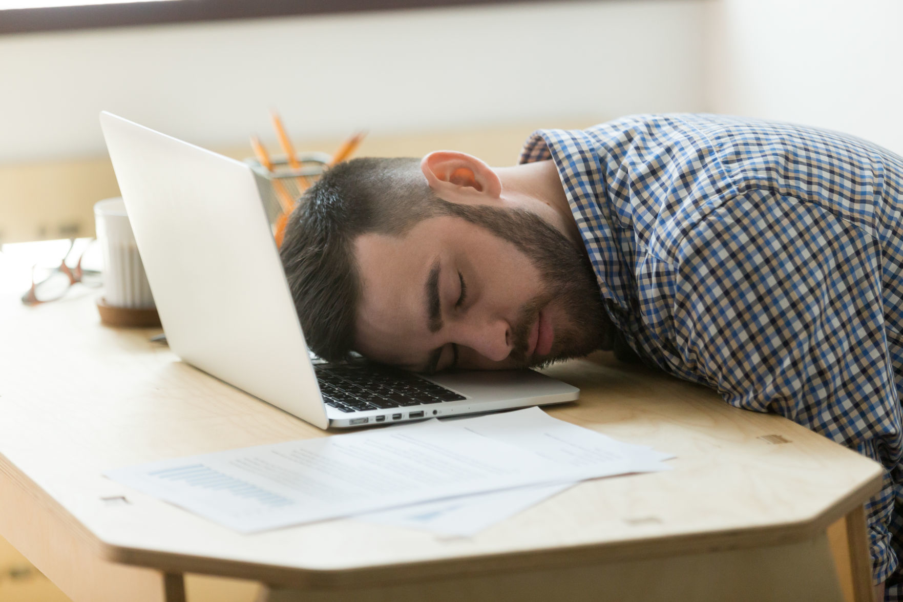 Bored tired office worker falling asleep on laptop, person tired after long working hours, exhausted because of increased workload. Concept of overwork, stress, boredom, no motivation, lack of sleep (copy)
